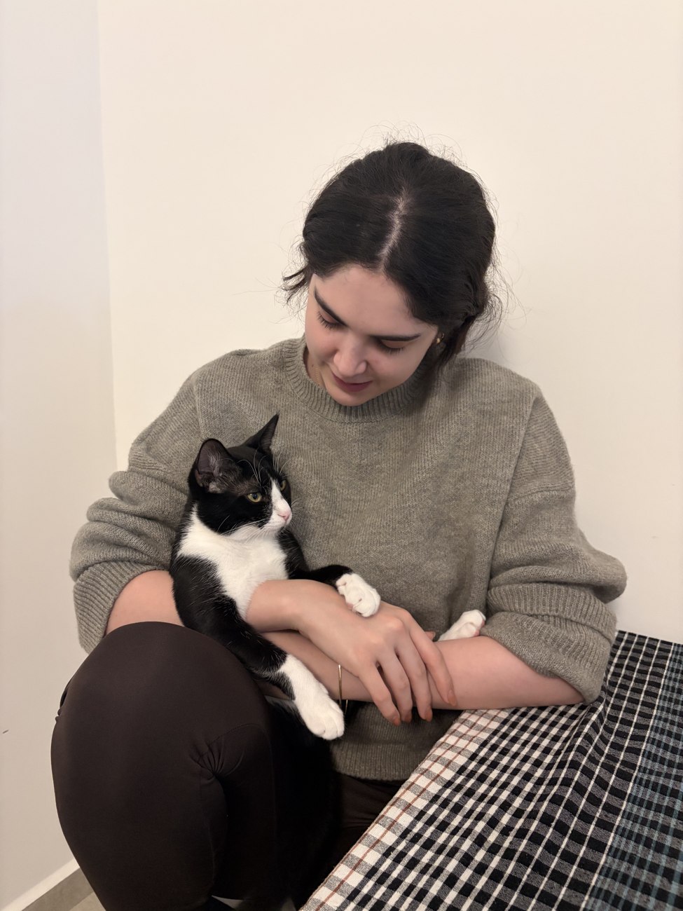 Mia holding a black and white cat