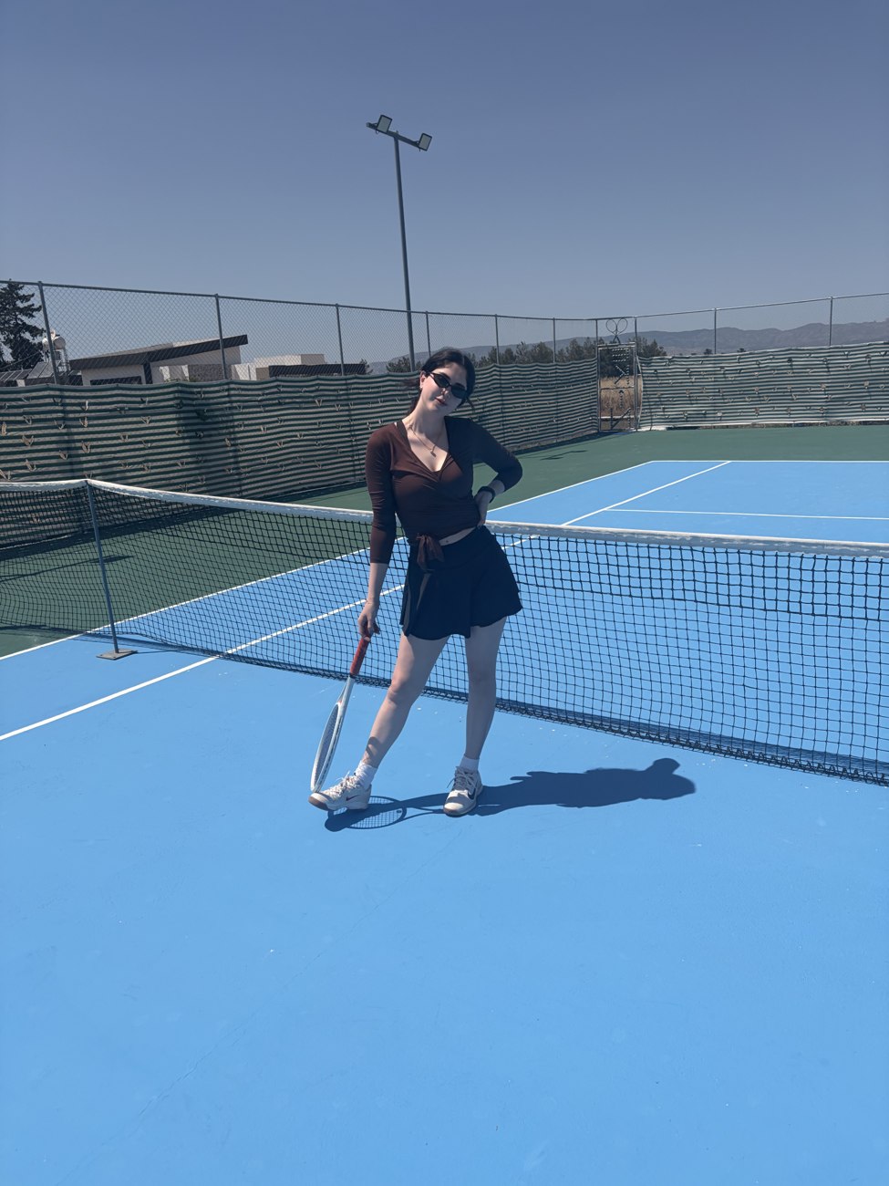 Mia on a blue tennis court